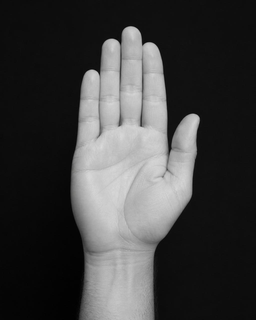 Right hand raised — ring finger subtly longer than index